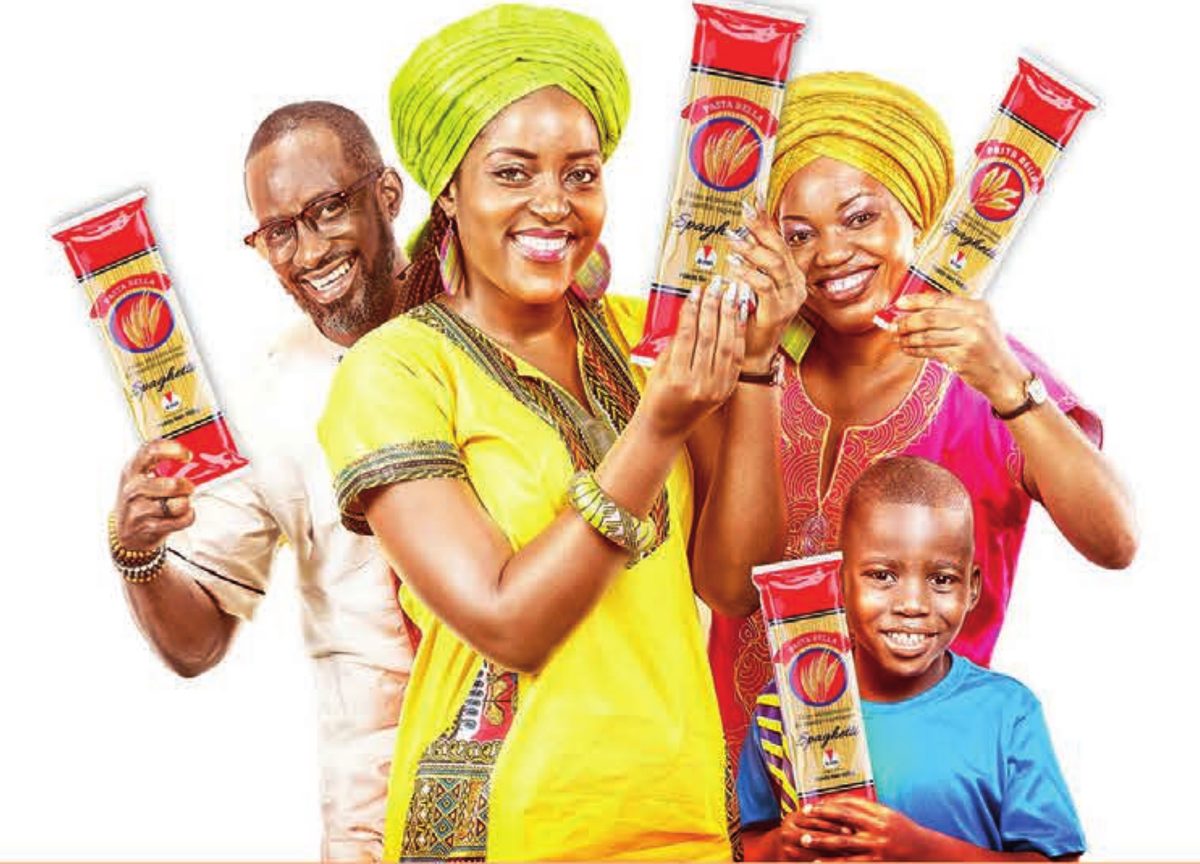 Une famille souriante tenant des paquets de spaghetti Pasta Bella