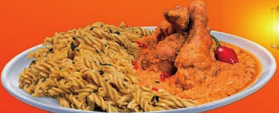 Assiette de torsades servies avec du poulet en sauce